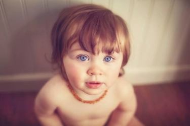 baby wearing amber teething necklace to soothe teething symptoms